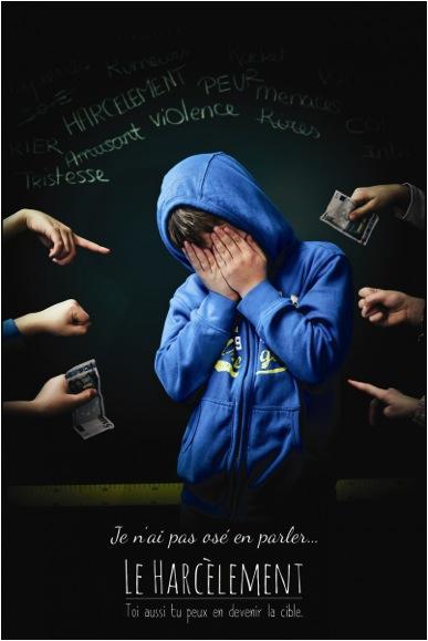 Campagne anti-harcèlement ("Je n'ai pas osé en parler") Un jeune, en sweet bleu à capuche, cache son visage de ses mains. Autour de lui six mains tendues, doigt pointé ou billets tenant des billets. En-dessous le mot "Harcèlement" en gros caractères, entre deux lignes de texte : "Je n'ai pas osé en parler" et "Toi aussi tu peux en devenir la cible".