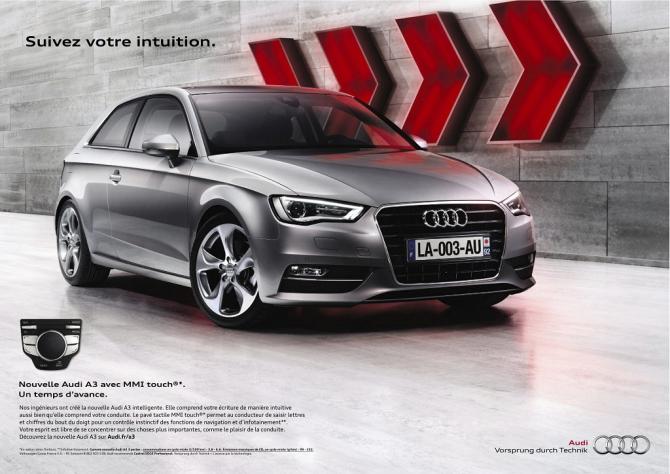 Publicité, voiture "Audi", modèle A3 Une voiture grise vue de profil, derrière elle un mur avec des flèches rouges indiquant la direction. En haut le slogan "Suivez votre intuition" et en bas texte et logo.
