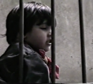 Un enfant derrière une grille