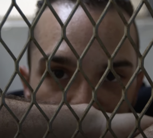 un homme derrière une grille