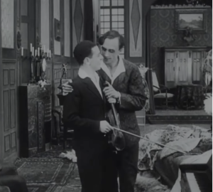 Image en noir et blanc. Un homme tient par l'épaule un jeune violoniste