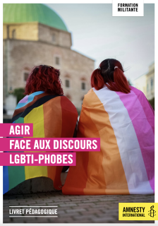 Deux femmes de dos avec un drapeau aux couleurs de l'arc en ciel